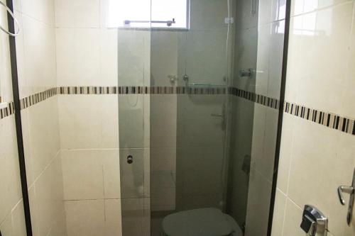 y baño con ducha de cristal y aseo. en Otimo apto 9 min do aeroporto em Florianopolis SC en Florianópolis