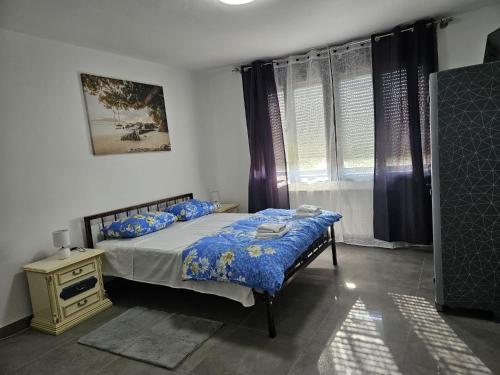 ein Schlafzimmer mit einem Bett und einem Fenster mit Vorhängen in der Unterkunft Kuća za odmor Antunović in Habjanovci