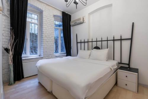 a bedroom with a large white bed and windows at 5 Apartment Galata in Istanbul