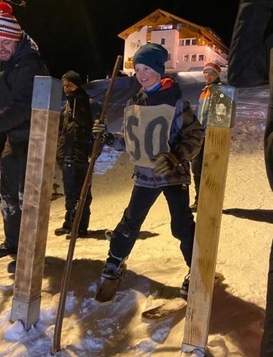 a young boy is standing in the snow with skis at Nonas B&B in Galtür