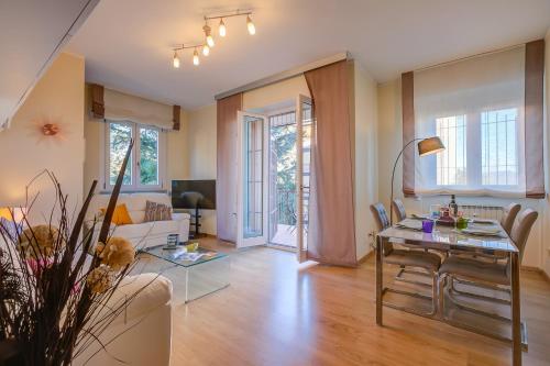 - un salon avec une table, des chaises et un canapé dans l'établissement Alelù Classy And Chic Apartment - Happy Rentals, à Stresa