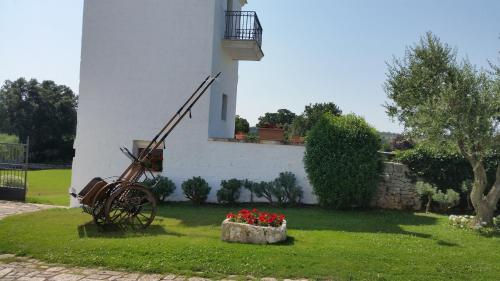 a building with a bicycle and flowers in a yard at Masseria Luco in Martina Franca