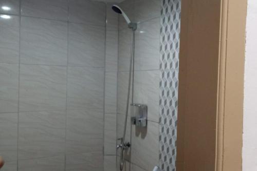 y baño con ducha y puerta de cristal. en OYO 93457 White House Syariah, en Kubang