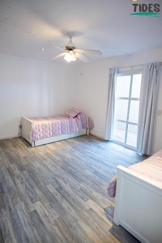 a bedroom with two beds and a ceiling fan at TIDES Apart de playa in Ostende