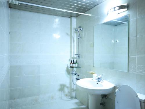 a white bathroom with a sink and a toilet at Goodstay Andong Park Hotel in Andong