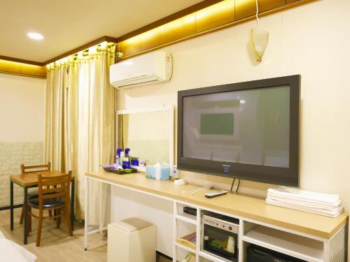 a hotel room with a television on a wall at Goodstay Andong Park Hotel in Andong