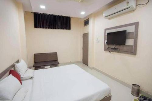 una camera con letto bianco e TV di Hotel Swarat By BookingCare a Satna