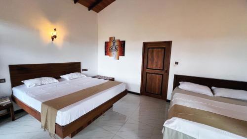 a bedroom with two beds and a door at The lookout lodge in Tangalle