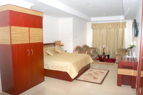 een slaapkamer met een bed en een kast erin bij Hotel KPM Tripenta in Palakkad
