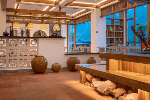 a large room with vases on the floor and windows at Zhangjiajie Qiquan Vacation B&B in Zhangjiajie