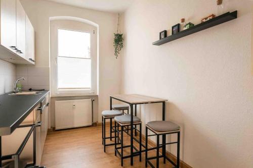 a kitchen with a table and stools in a room at Ferienwohnung Bali Style mit High Speed WLAN und gratis Parkplatz in Gera