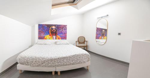 een slaapkamer met een bed en een schilderij aan de muur bij Élégant 2 pièces proche de Paris et Disneyland in Neuilly-sur-Marne