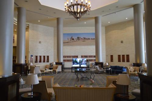 a lobby of a hotel with couches and a television at Golden Tulip Hail in Hail