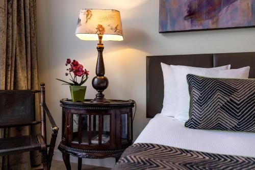 a bedroom with a bed with a lamp on a table at Jupiter Hotel in Amsterdam