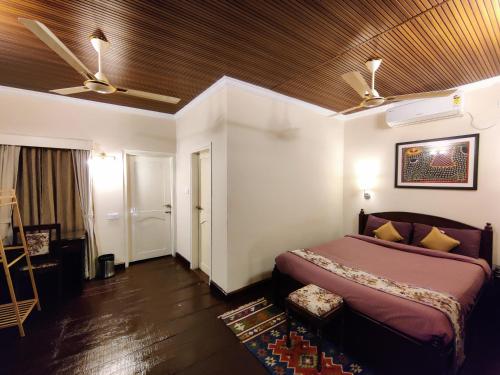a bedroom with a bed and a ceiling fan at Bougainvillea Retreat & Spa in Kāhārpāra