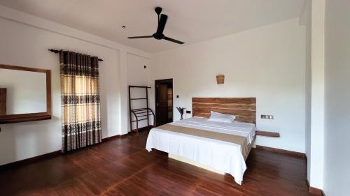 a bedroom with a bed and a ceiling fan at The lookout lodge in Tangalle