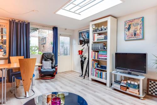a living room with a flat screen tv and a table at Gezellig appartement in de mooie oude binnenstad van Alkmaar in Alkmaar