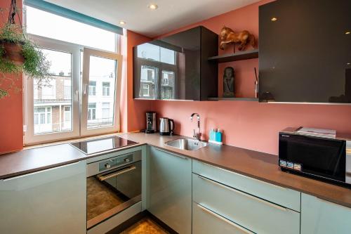 a kitchen with a sink and a microwave at Jupiter Hotel in Amsterdam