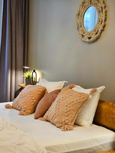 a bed with brown and white pillows and a mirror at Silversmith's Residence in Old Riga in Riga
