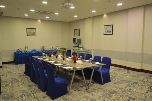a conference room with a long table and blue chairs at Golden Tulip Hail in Hail