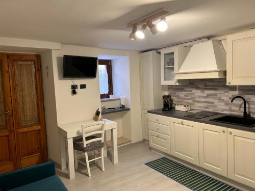 a kitchen with a desk and a tv on the wall at Casa Martino in Norcia