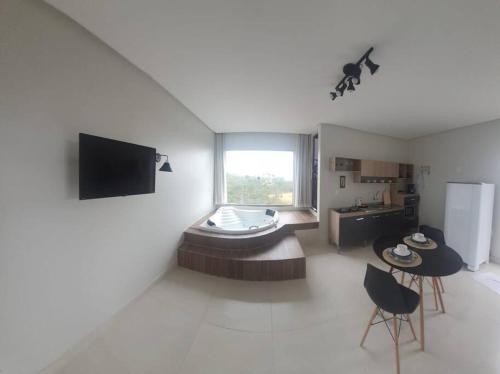 un soggiorno con vasca nell'angolo di una camera di Flat Safira com hidro - Chapada dos Veadeiros a Alto Paraíso de Goiás