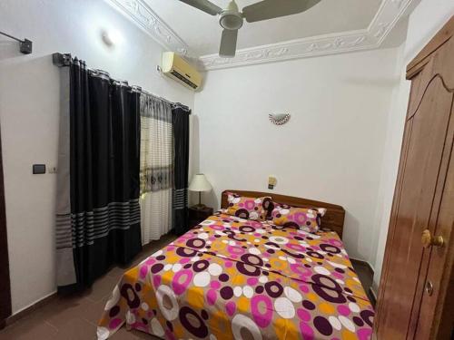 a bedroom with a bed with a colorful comforter at Appartement F2 Meublé in Cotonou