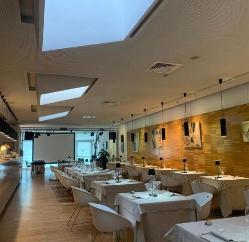 a dining room with white tables and white chairs at Schio Hotel in Schio