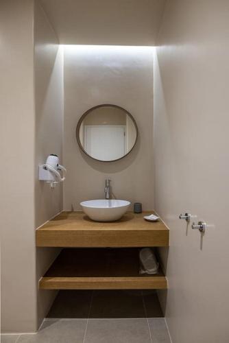 a bathroom with a sink and a mirror at La Chapelle Ouest & Grand suite in Agios Romanos