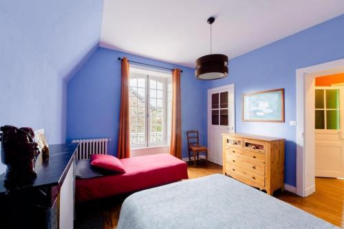 a bedroom with blue walls and a bed and a chair at Villa La Côte du Chat in Hédé