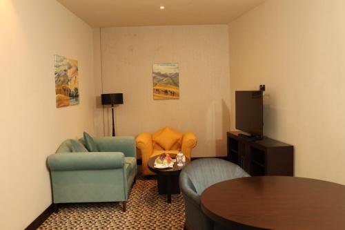 a living room with two chairs and a table at Golden Tulip Hail in Hail