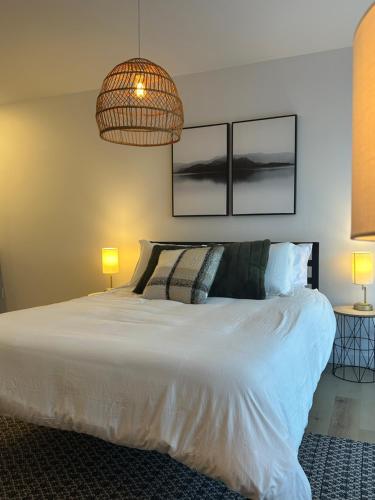 a bedroom with a large white bed with two lamps at L’espace Mysa - Studio Lugna in Mont-Tremblant