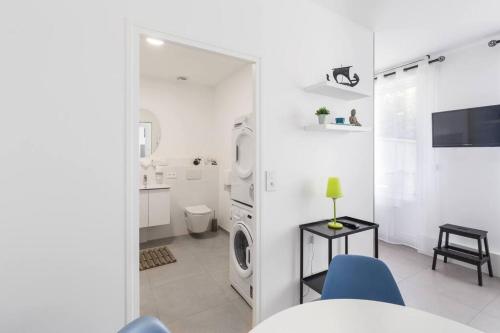 a white room with a washing machine and a bathroom at Vinaura - Appartement élégant avec parking in Reims