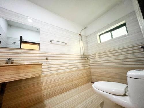 a bathroom with a toilet and a mirror at The Grand Hotel Multan in Multan