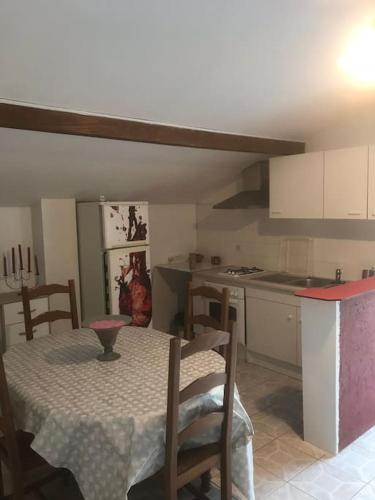 une cuisine avec une table et des chaises dans une pièce dans l'établissement Louez l’étage d une maison basque à 5mn de Bayonne, à Mouguerre