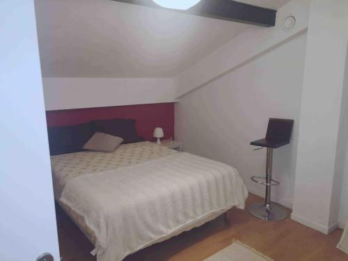 um quarto com uma cama e um candeeiro em Louez l’étage d une maison basque à 5mn de Bayonne em Mouguerre