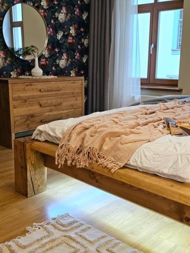 a bedroom with a bed with a dresser and a mirror at Silversmith's Residence in Old Riga in Riga