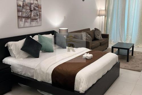 uma cama grande num quarto com um sofá em Palm View East Jumeira - Studio Apartment em Dubai
