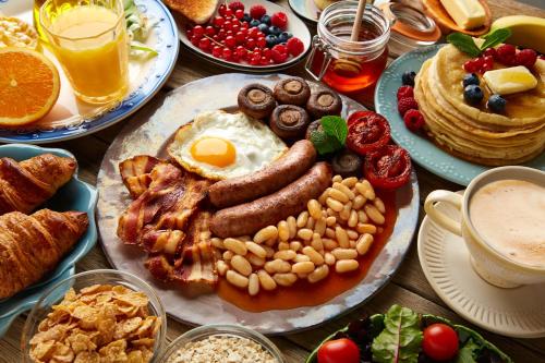 a table with a breakfast plate of sausage eggs and bread at Hilton Dubai The Walk in Dubai
