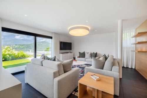 a living room with two couches and a table at Villa Girandola with private, heated pool in Lugano