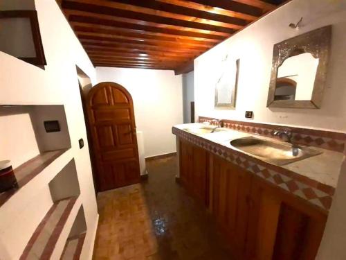 a bathroom with two sinks and a wooden door at Entire Private House in Fez Medina! in Fez