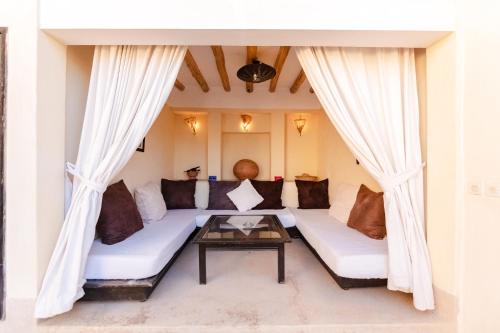 a living room with a couch and a table at Riad Rouge Gorge in Marrakesh