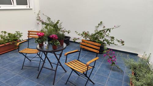 a patio with a table and chairs and plants at AKAKIA VILLA NAFPLIO in Nafplio