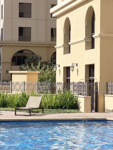 a hotel swimming pool with a chair next to a building at GMA Rimal5 4BR Sea View in Dubai