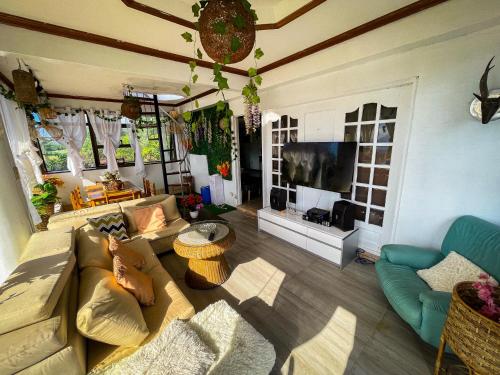 een woonkamer met een bank en een televisie bij Lovely Villa in Tagaytay with Pool & Full Taal View in Tagaytay
