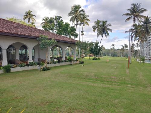 - un bâtiment avec une grande cour plantée de palmiers dans l'établissement Canterbury Residence Garden Apartment, à Kahatuduwa