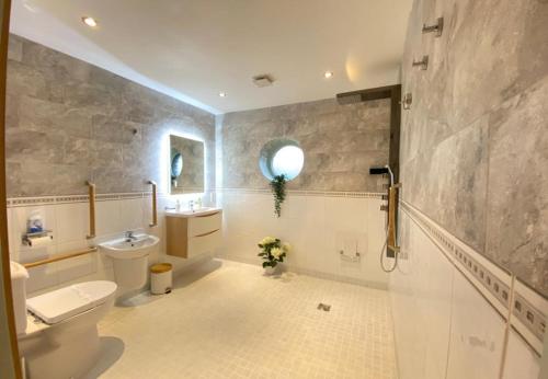 La salle de bains est pourvue de toilettes, d'un lavabo et d'un miroir. dans l'établissement Lune Cottage nestled between Lake District and Yorkshire Dales, à Tebay