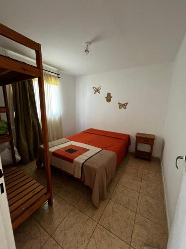 a bedroom with a bed with a red comforter at Complejo La Rosa Molinari Cosquin in Córdoba