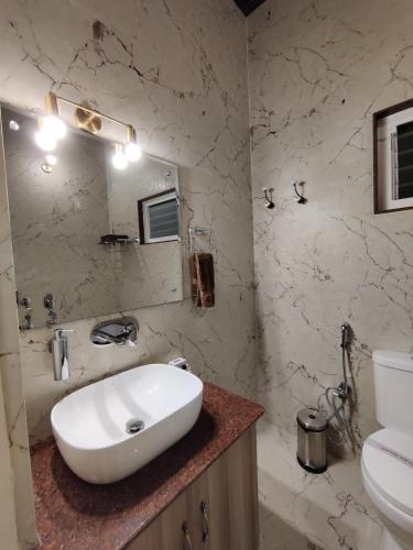 a bathroom with a white sink and a toilet at Bougainvillea Retreat & Spa in Kāhārpāra