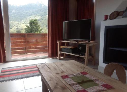 uma sala de estar com uma televisão de ecrã plano e uma mesa em Catedral View minimo 4 noches em San Carlos de Bariloche